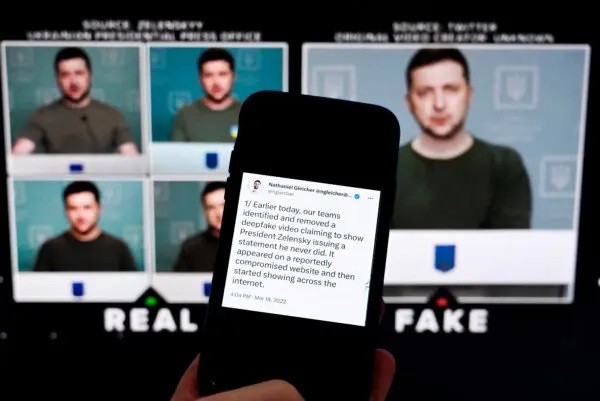 Телефон, показывающий экран, на котором демонстрируется фейковое видео, где президент Украины Владимир Зеленский призывает своих солдат сложить оружие, Вашингтон, 30 января 2023 года. (OLIVIER DOULIERY/AFP via Getty Images)