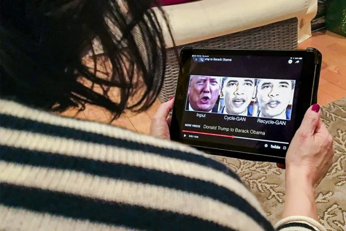 Женщина просматривает сфальсифицированное видео с президентами Дональдом Трампом и Бараком Обамой, иллюстрирующее, как фейковые технологии могут обманывать зрителей, в Вашингтоне 24 января 2019 г. (ROB LEVER/AFP via Getty Images)