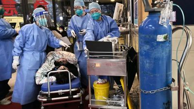 Медицинские работники обслуживают пациента с COVID в Шанхае, 14 января 2023 года. (Kevin Frayer/Getty Images)