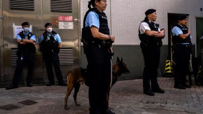 Сотрудники полиции патрулируют возле избирательного участка во время выборов в окружной совет в Гонконге 10 декабря 2023 года. (Louise Delmotte/AP Photo)
