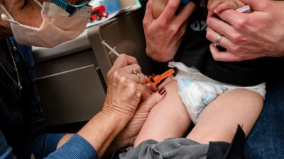 Годовалый ребёнок получает прививку Pfizer COVID-19 в Сиэтле, штат Вашингтон, 21 июня 2022 года. (David Ryder/Getty Images)