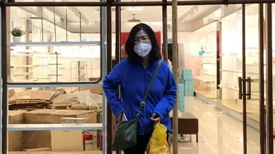 Чжан Чжань у строительных лесов возле магазина во время визита в Ухань, провинция Хубэй, Китай, 11 апреля 2020 года. (Courtesy of Melanie Wang via AP)