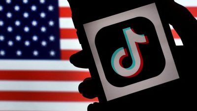 TikTok отображается на экране iPhone перед американским флагом в Арлингтоне, Вирджиния, 3 августа 2020 года. (Olivier Douliery/ AFP via Getty Images)