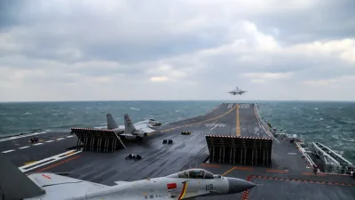 Китайские истребители J-15 взлетают с палубы авианосца «Ляонин» во время военных учений в Жёлтом море, у восточного побережья Китая, 23 декабря 2016 г. (STR/AFP via Getty Images)