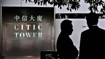 Двое мужчин беседуют рядом с офисом CITIC Pacific в Гонконге, 8 апреля 2009 года. (Philippe Lopez/AFP via Getty Images)