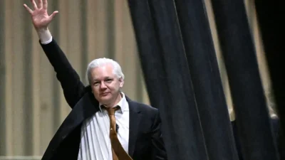 Основатель WikiLeaks Джулиан Ассанж машет рукой после прибытия в аэропорт в Канберре, Австралия, 26 июня 2024 года. (William West/AFP via Getty Images)