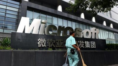 Уборщик проходит мимо вывески Microsoft возле здания офиса Microsoft в Пекине, 31 июля 2014 г. (Greg Baker/AFP/Getty Images)