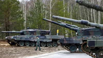 Польский солдат идёт рядом с танками Leopard 2 во время тренировки на испытательном полигоне в Свитошуве, Польша, 13 февраля 2023 года. (Michal Dyjuk /AP Photo)