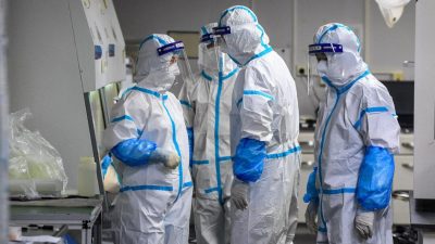 Лаборанты в средствах индивидуальной защиты работают над образцами, подлежащими тестированию на COVID-19, в испытательном центре в Ухане, 4 августа 2021 года. (STR/AFP via Getty Images)