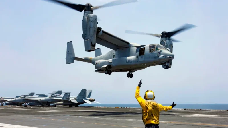 Помощник авиационного боцмана 2-го класса Николас Хокинс подаёт сигнал MV-22 Osprey о посадке на полётную палубу американского авианосца «Авраам Линкольн» в Аравийском море 17 мая 2019 года. (Mass Communication Specialist 3rd Class Amber Smalley/U.S. Navy via AP)