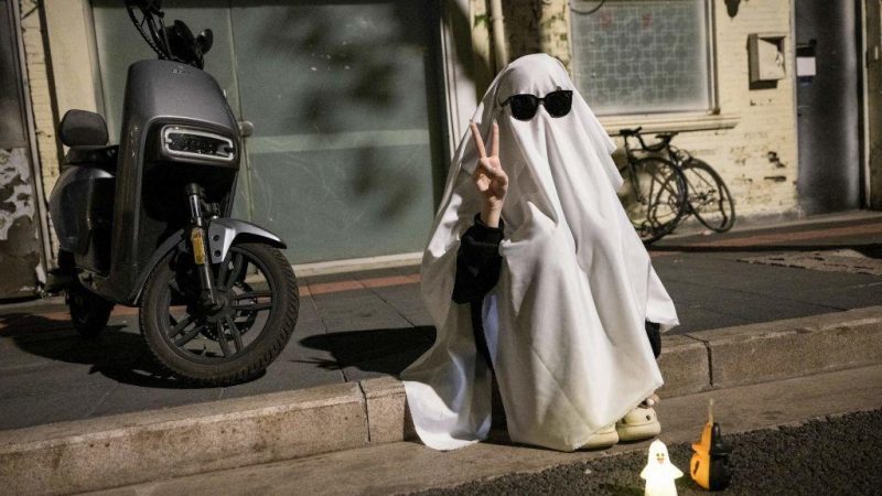 Человек в костюме, сидящий на улице в преддверии Хэллоуина в Шанхае, Китай, 30 октября 2023 года. (STR/AFP via Getty Images)