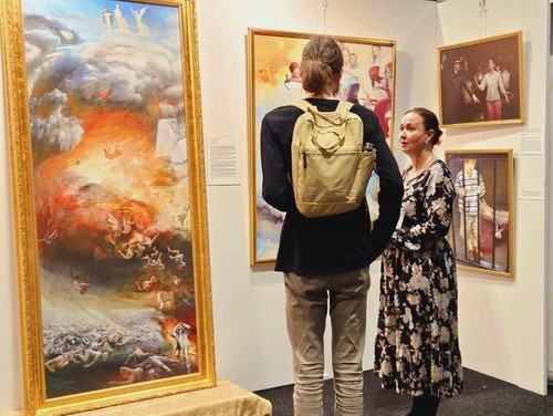 Посетители останавливаются перед картинами, чтобы узнать больше о полотнах, которые их заинтересовали, и экскурсоводы рассказывают им истории, лежащие в основе сюжета картин. (Фото: minghui.org)