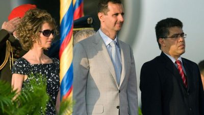 Президент Сирии Башар аль-Асад (в центре) и его жена Асма аль-Асад стоят рядом с вице-президентом Венесуэлы Элиасом Хауа (справа) по прибытии в международный аэропорт Майкетия в Каракасе, 25 июня 2010 года. (MIGUEL GUTIERREZ/AFP via Getty Images) 