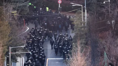 Полицейские и следователи Управления по борьбе с коррупцией проходят в резиденцию президента Южной Кореи Юн Сок Ёля в Сеуле, 15 января 2025 года. (Kim Hong-Ji/Reuters)