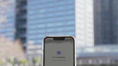 Приложение DeepSeek на мобильном телефоне перед зданием, в котором находится штаб-квартира китайского стартапа DeepSeek в Ханчжоу, провинция Чжэцзян, на востоке Китая 28 января 2025 года. (Agatha Cantrill/AFP via Getty Images)
