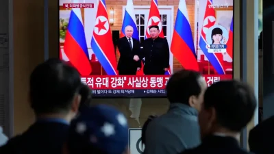 На экране телевизора лидер Северной Кореи Ким Чен Ын и президент России Владимир Путин в Пхеньяне во время новостной программы на железнодорожной станции Сеула в Южной Корее, 28 апреля 2025 года. (Ahn Young-joon/AP)