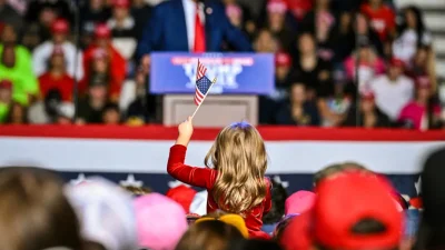 Ребёнок держит американский флаг, пока Дональд Трамп выступает на предвыборном митинге в Государственном университете Сагино-Вэлли в Сагино, штат Мичиган, 3 октября 2024 года. (Jim Watson/AFP via Getty Images)