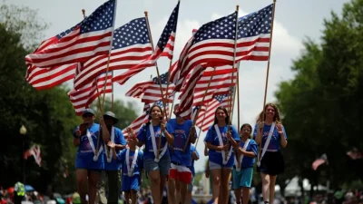 Люди несут флаги США во время празднования Дня независимости в Вашингтоне, 4 июля 2019 года. (Carlos Barria/Reuters)
