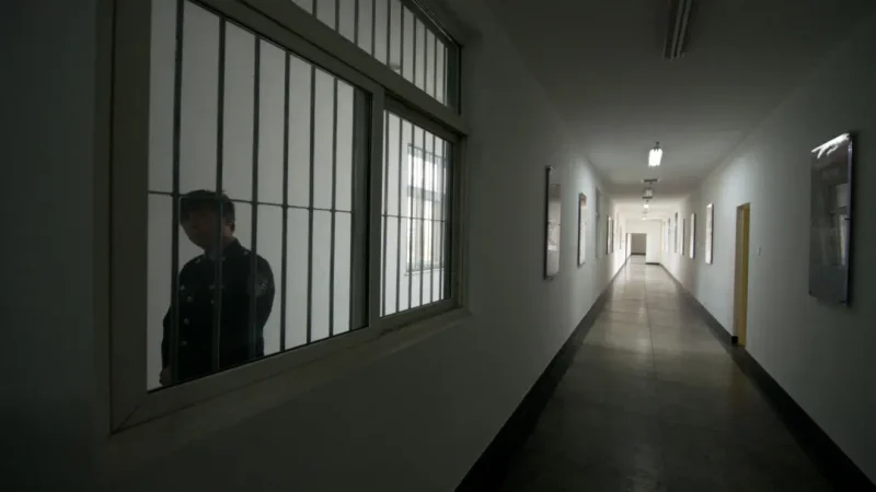 Охранник смотрит в окно коридора в центре содержания под стражей в Пекине, 25 октября 2012 года. (Ed Jones/AFP via Getty Images)
