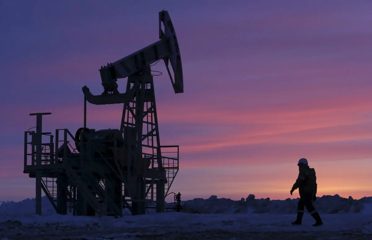 Рабочий проходит мимо насосной установки на нефтяном месторождении, принадлежащем компании «Башнефть», недалеко от села Николо-Берёзовка, к северо-западу от Уфы, Башкортостан, Россия, 28 января 2015 года. (Sergei Karpukhin/Reuters)