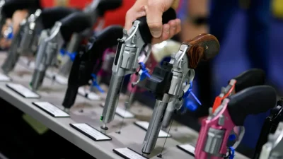Посетитель берёт в руки револьвер на стенде Charter Arms на выставке NRA в Атланте, 25 апреля 2025 года. (Joe Raedle/Getty Images)