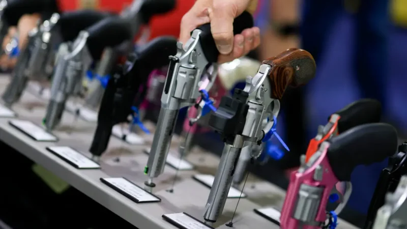 Посетитель берёт в руки револьвер на стенде Charter Arms на выставке NRA в Атланте, 25 апреля 2025 года. (Joe Raedle/Getty Images)