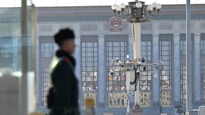 Китайский полицейский стоит на страже у Большого зала народных собраний в Пекине, 26 февраля 2025 года. (Pedro Pardo/AFP via Getty Images)