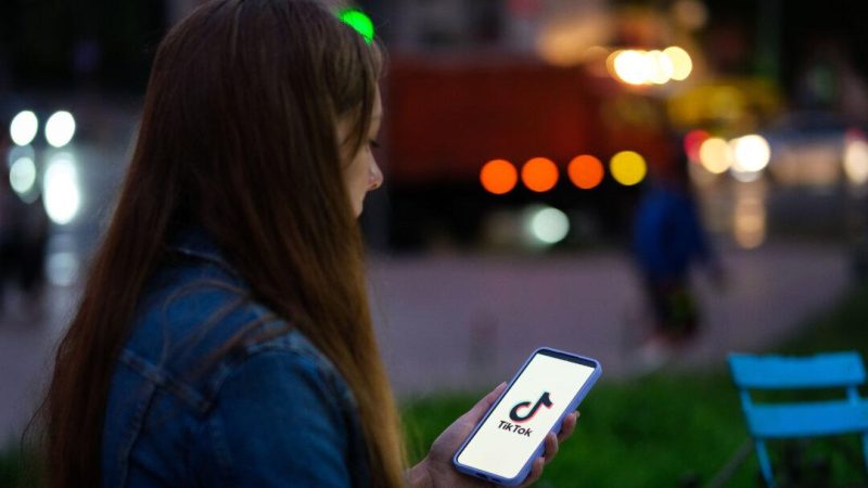 Девушка держит в руках телефон с приложением TikTok. (Oleksii Pydsosonnii/The Epoch Times)
