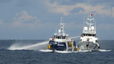 12 октября 2025 года судно береговой охраны Китая (справа) обстреляло из водомёта филиппинское судно BRP Datu Pagbuaya вблизи острова Титу, который местные жители называют островом Пагаса, в Филиппинском море. (Philippine Coast Guard via AP)

