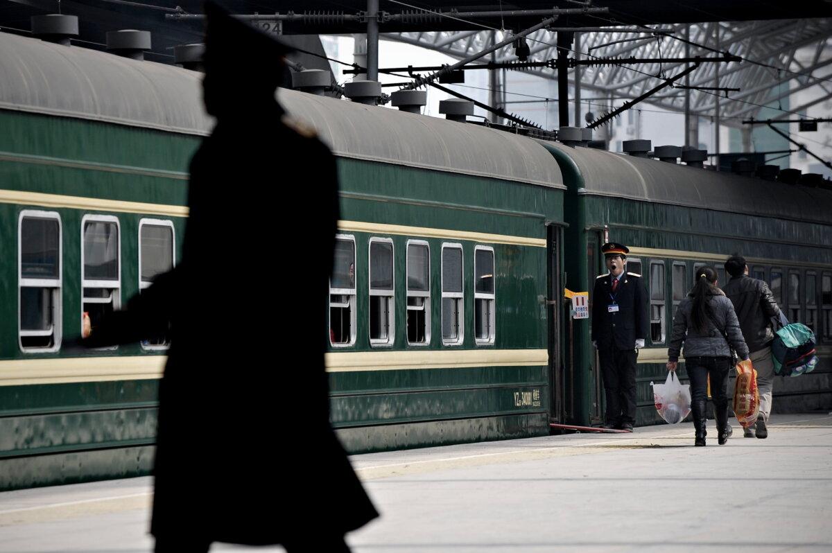 Пассажиры садятся в зелёный поезд на центральном железнодорожном вокзале Шанхая 29 января 2009 года. (Philippe Lopez/AFP via Getty Images)