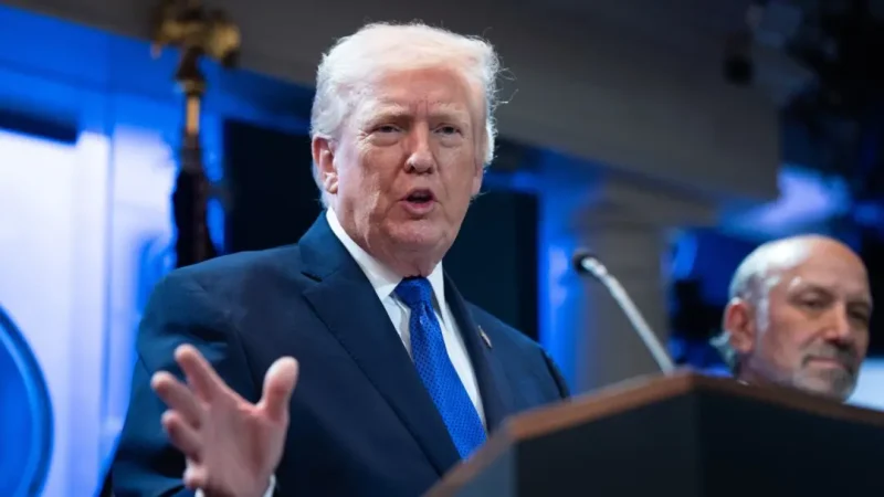 Дональд Трамп выступает за трибуной в Белом доме на фоне синего освещения, жестикулируя рукой во время речи о введении новых импортных тарифов в феврале 2026 года.