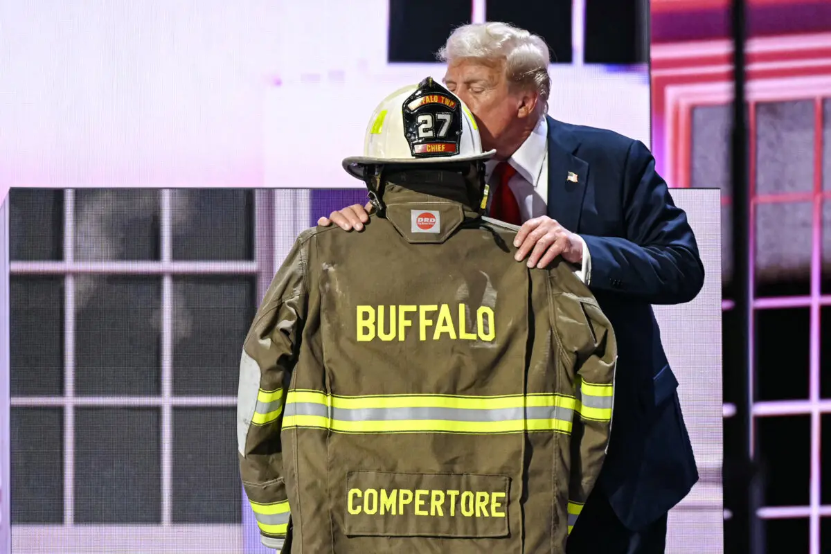 Дональд Трамп на сцене целует шлем и куртку убитого пожарного Кори на Fiserv Forum.
