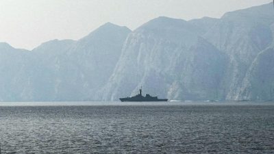Военный корабль в Ормузском проливе на фоне скалистых берегов.