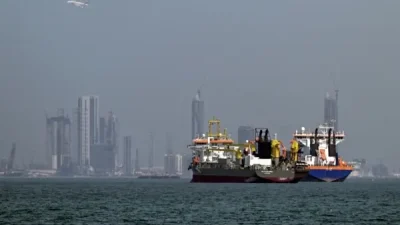 Нефтяные танкеры и грузовые суда в порту на фоне городского горизонта