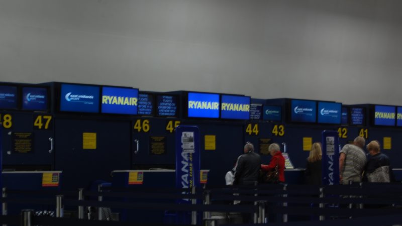 Зал вылета крупного международного аэропорта с пассажирами