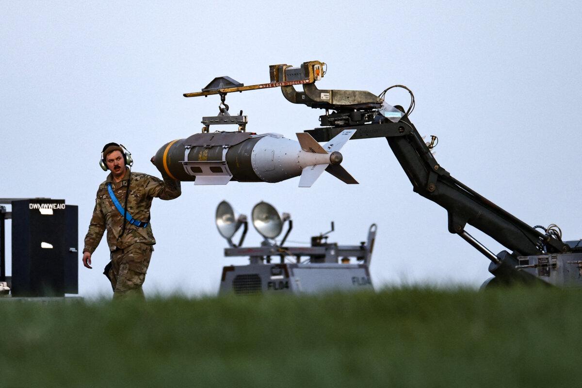 Военнослужащие ВВС США загружают боеприпасы Joint Direct Attack Munitions в бомбардировщик B-1 Lancer на взлётно-посадочной полосе авиабазы Фэрфорд в Англии, 11 марта 2026 года.