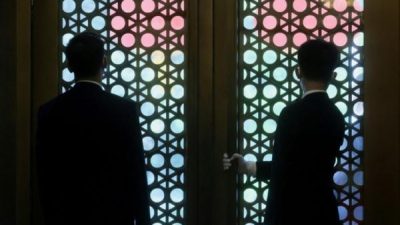 Силуэты китайских чиновников перед традиционными дверями