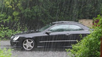 Черный автомобиль под сильным проливным дождем, иллюстрация к прогнозу погоды о штормовом предупреждении в Краснодарском крае и республиках Северного Кавказа.