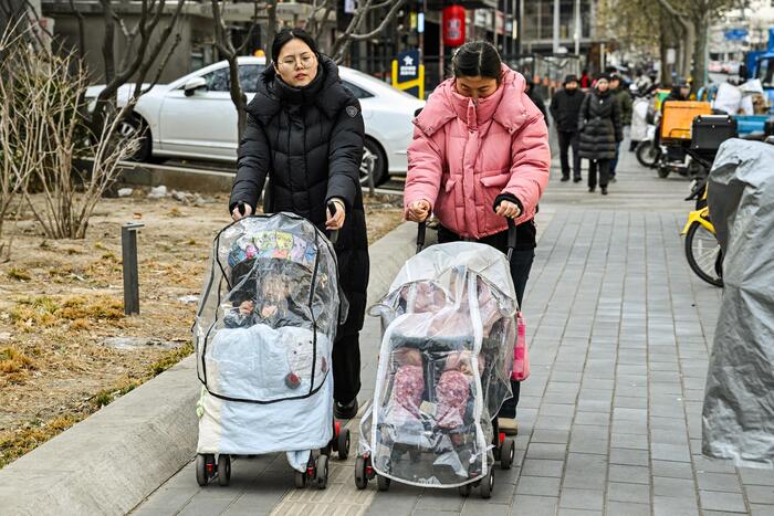 Женщины с детскими колясками на улице Пекина, 4 января 2026 года. В 2025 году число новорождённых в Китае достигло рекордно низкого уровня, а доля взрослых в возрасте 60 лет и старше составила около 23%.